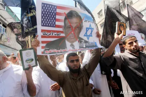 Palestinians hold placards as they shout anti-U.S. slogans during a demonstration against the controversial film 'Innocence of Muslims' in Khan Younis southern Gaza strip, on September 14, 2012. The controversial low bud...