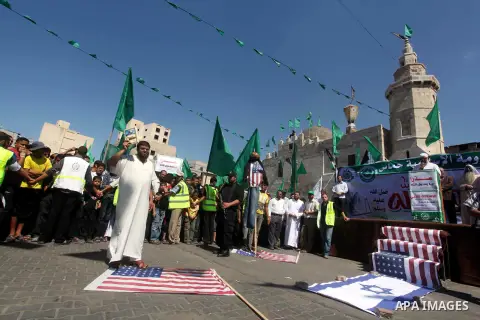 Palestinians walk on the U.S. flag during a demonstration against the controversial film 'Innocence of Muslims' in Khan Younis southern Gaza strip, on September 14, 2012. The controversial low budget film reportedly made...