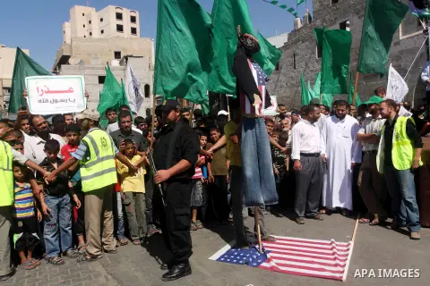 Palestinians walk on the U.S. flag during a demonstration against the controversial film 'Innocence of Muslims' in Khan Younis southern Gaza strip, on September 14, 2012. The controversial low budget film reportedly made...