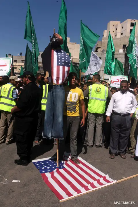 Palestinians walk on the U.S. flag during a demonstration against the controversial film 'Innocence of Muslims' in Khan Younis southern Gaza strip, on September 14, 2012. The controversial low budget film reportedly made...