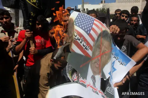 Palestinians burn a portrait of the director of controversial film 'Innocence of Muslims' during a demonstration in Khan Younis southern Gaza strip, on September 14, 2012. The controversial low budget film reportedly mad...