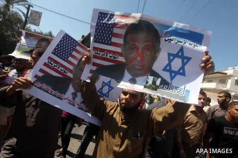 Palestinians hold placards as they shout anti-U.S. slogans during a demonstration against the controversial film 'Innocence of Muslims' in Khan Younis southern Gaza strip, on September 14, 2012. The controversial low bud...