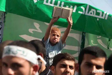 A Palestinian child holds holy Qur'an during a demonstration against the controversial film 'Innocence of Muslims' in Gaza City, on September 14, 2012. The controversial low budget film reportedly made by an Israeli-Amer...