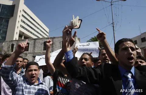 A Palestinian holds up a copy of the Quran during a demonstration against the controversial film 'Innocence of Muslims' in the West Bank city of Nablus, on September 14, 2012. The controversial low budget film reportedly...