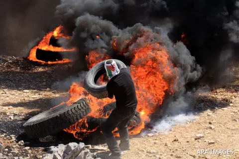 A Palestinian protester burn a tire during a demonstration against the expropriation of Palestinian land by Israel in the village of Kafr Qaddum, near the West Bank city of Nablus, on Sept. 14, 2012. Photo by Nedal Eshta...