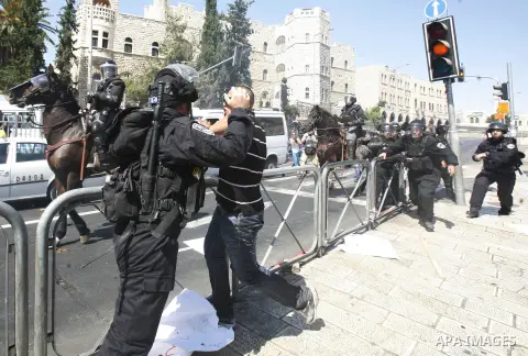 Israeli policeman clashes with a Palestinian protester during a demonstration against the controversial film 'Innocence of Muslims' in front of al-Aqsa Mosqe in Jerusalem, on September 14, 2012. The controversial low bud...