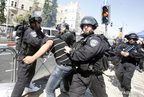Israeli policemen detain a Palestinian protester during a demonstration against the controversial film 'Innocence of Muslims' in front of al-Aqsa Mosqe in Jerusalem, on September 14, 2012. The controversial low budget fi...