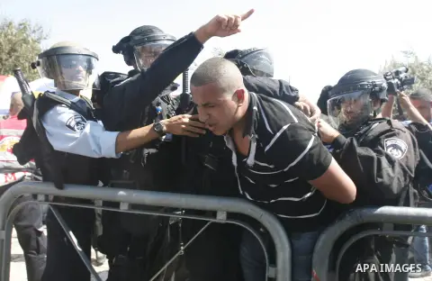 Israeli policemen detain a Palestinian protester during a demonstration against the controversial film 'Innocence of Muslims' in front of al-Aqsa Mosqe in Jerusalem, on September 14, 2012. The controversial low budget fi...