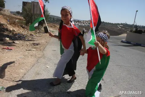 Palestinian girls hold up national flags during a protest against the confiscation of Palestinian land to expand Jewish settlements in the West Bank village of Nabi Saleh near Ramallah on September 14, 2012.The weekly de...
