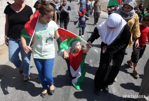 Palestinians and left-wing Israeli hold up Palestinian flags during a protest against the confiscation of Palestinian land to expand Jewish settlements in the West Bank village of Nabi Saleh near Ramallah on September 14...