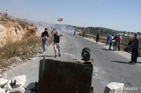 Palestinians make a road barricade during a protest against the confiscation of Palestinian land to expand Jewish settlements in the West Bank village of Nabi Saleh near Ramallah on September 14, 2012.The weekly demonstr...