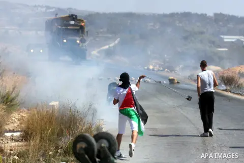 Palestinians throw stones at an Israeli foul smelling water cannon during clashes at a weekly protest against a nearby Jewish settlement, in the West Bank village of Nabi Saleh, near Ramallah, on Friday, Sept 14, 2012. T...