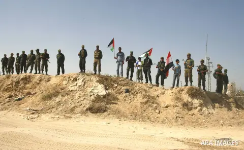 Palestinian children hold national flags and placards during a protest against the Egyptian decision to close the smuggling tunnels along the Gaza-Egypt border in Rafah, in the southern Gaza Strip, on Sept. 15, 2012. The...