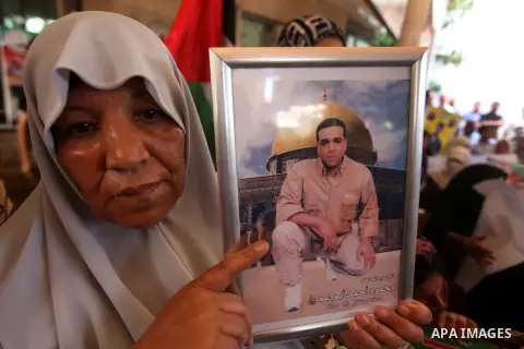 Palestinians hold a placard depicting jailed relatives during a protest in Gaza City calling for the release of Palestinian prisoners from Israeli jails September 17, 2012. Photo by Majdi Fathi