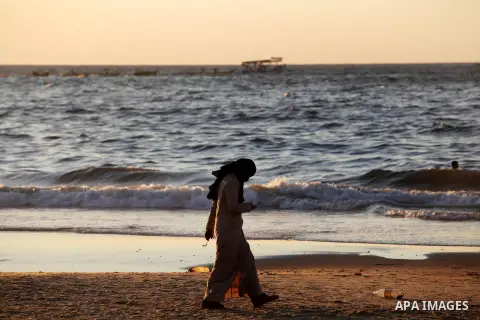 A Palestinian woman walks at the beach of Gaza city, Sept 17, 2012. Photo by Majdi Fathi