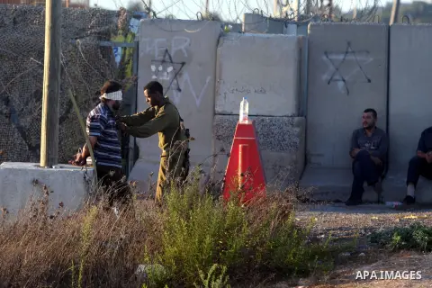 An Israeli soldier detains a Palestinian man on the Atara checkpoint in the West Bank city of Ramallah on September 17, 2012. Photo by Issam Rimawi