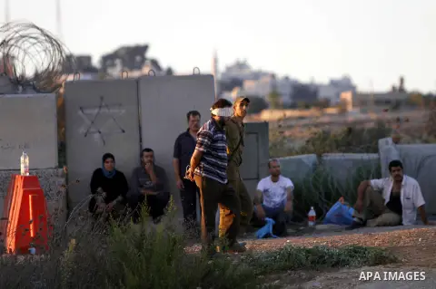 An Israeli soldier detains a Palestinian man on the Atara checkpoint in the West Bank city of Ramallah on September 17, 2012. Photo by Issam Rimawi