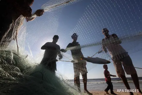 Palestinian fishers prepare to throw their trawl in the sea on the beach of Gaza city, Sept. 18, 2012 . Photo by Majdi Fathi