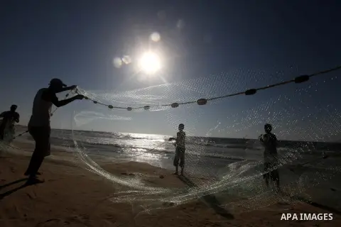 Palestinian fishers prepare to throw their trawl in the sea on the beach of Gaza city, Sept. 18, 2012 . Photo by Majdi Fathi