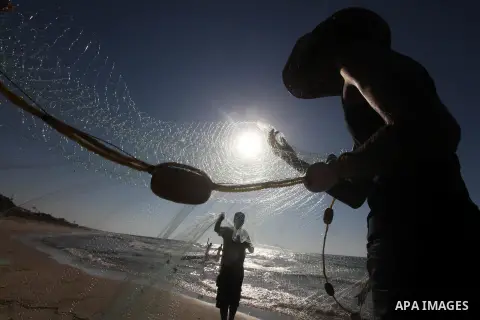 Palestinian fishers prepare to throw their trawl in the sea on the beach of Gaza city, Sept. 18, 2012 . Photo by Majdi Fathi