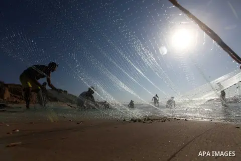 Palestinian fishers prepare to throw their trawl in the sea on the beach of Gaza city, Sept. 18, 2012 . Photo by Majdi Fathi