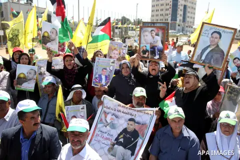Palestinians hold portraits of relatives held in Israeli jails during a protest to calling for their liberty, in the West Bank city of Ramallah on September 19, 2012. Photo by Issam Rimawi