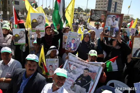 Palestinians hold portraits of relatives held in Israeli jails during a protest to calling for their liberty, in the West Bank city of Ramallah on September 19, 2012. Photo by Issam Rimawi