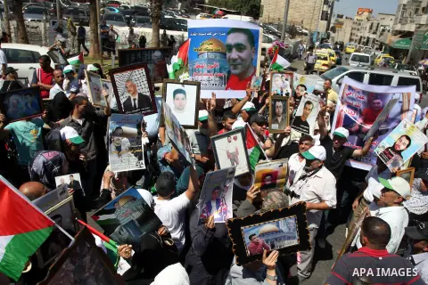 Palestinians hold portraits of relatives held in Israeli jails during a protest to calling for their liberty, in the West Bank city of Ramallah on September 19, 2012. Photo by Issam Rimawi