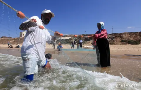A Palestinian family work in fishing, tow their trawl from the sea in Deir al-Balah Palestinian refugee camp, central of Gaza Strip, on September 19, 2012. Photo by Majdi Fathi