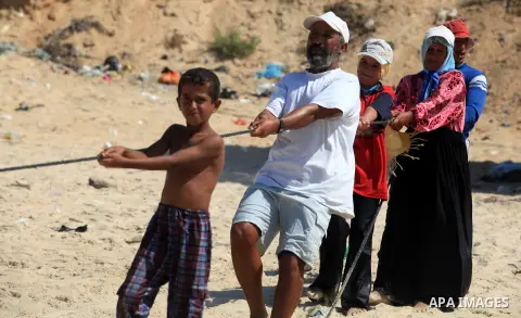 A Palestinian family work in fishing, tow their trawl from the sea in Deir al-Balah Palestinian refugee camp, central of Gaza Strip, on September 19, 2012. Photo by Majdi Fathi