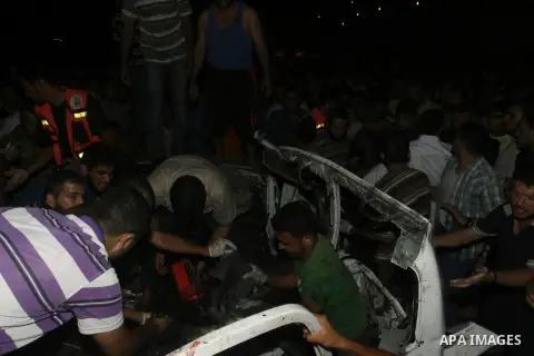 Palestinians gather around the wreckage of a car targeted by an Israeli aircraft in the town of Rafah in southern Gaza Strip on September 19, 2012. An Israeli air strike on the Gaza Strip killed two Palestinians and woun...