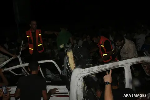 Palestinians gather around the wreckage of a car targeted by an Israeli aircraft in the town of Rafah in southern Gaza Strip on September 19, 2012. An Israeli air strike on the Gaza Strip killed two Palestinians and woun...