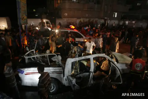 Palestinians gather around the wreckage of a car targeted by an Israeli aircraft in the town of Rafah in southern Gaza Strip on September 19, 2012. An Israeli air strike on the Gaza Strip killed two Palestinians and woun...