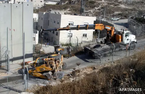 An Israeli bulldozer inverses during sealing off the Ras Khamis Checkpoint northen jerusalem on Sept. 20, 2012. The Israeli Ministry of Defence has announced its plans to seal off one of two checkpoints through which the...