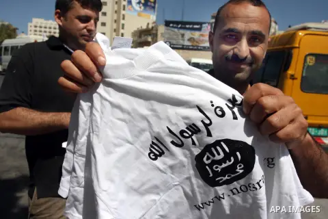 A Palestinian man displays a T-shirt reading in Arabic "Muhammad is the messenger of Allah" during a campaign called by Palestinian activists against the anti-Islam movie entitled 'Innocence of Muslims' made in the U.S.,...