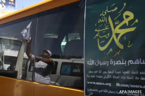 A Palestinians youth pastes a poster on acar reading in Arabic "anyone but prophet Muhammad" during a campaign called by Palestinian activists against the anti-Islam movie entitled 'Innocence of Muslims' made in the U.S....