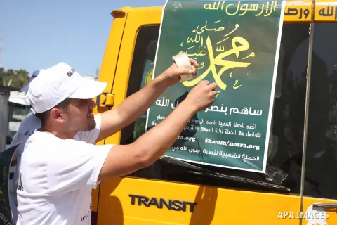 A Palestinians youth pastes a poster on acar reading in Arabic "anyone but prophet Muhammad" during a campaign called by Palestinian activists against the anti-Islam movie entitled 'Innocence of Muslims' made in the U.S....