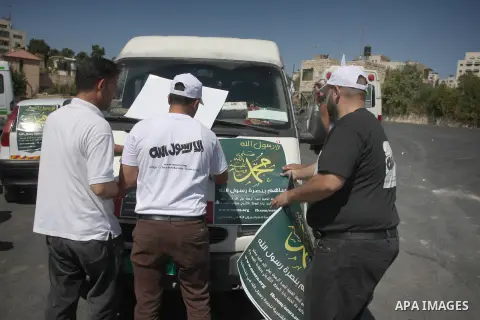Palestinians paste posters on cars reading in Arabic "anyone but prophet Muhammad" during a campaign called by Palestinian activists against the anti-Islam movie entitled 'Innocence of Muslims' made in the U.S., in the W...