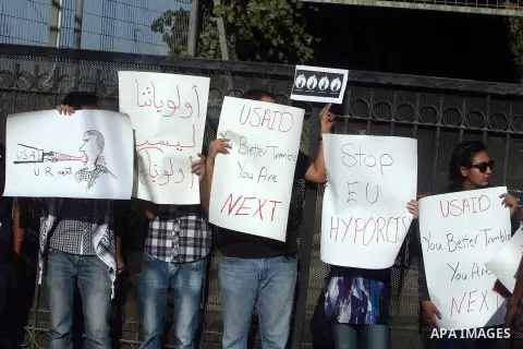 Palestinian activists hold placards as they block the entrance of the EU police office during a protest refusal to the policy of European Union toward Palestinian issue and the prisoners in the Israeli jails, in the West...