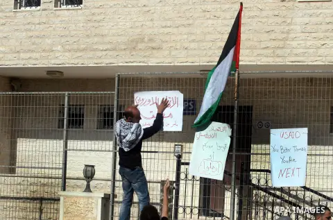 A Palestinian activist holds a placard reading in Arabic "EU Closed, by order of Palestinians" during a protest refusal to the policy of European Union toward Palestinian issue and the prisoners in the Israeli jails, in...