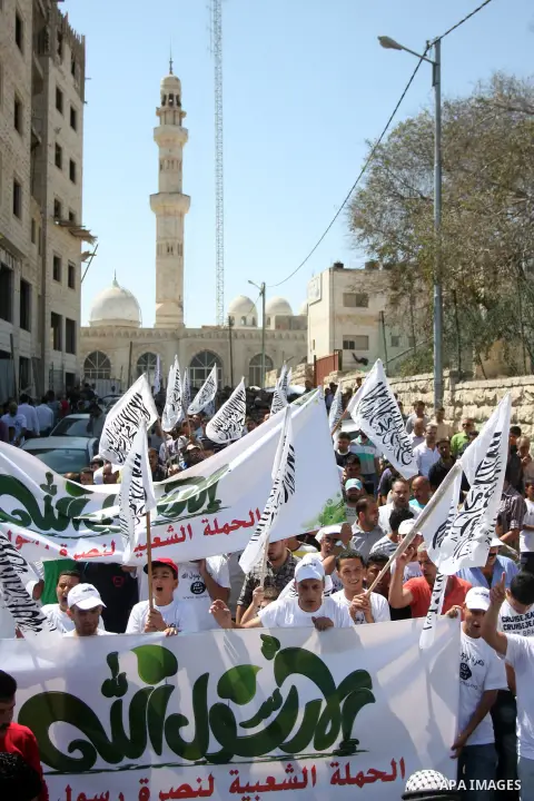 Palestinian protesters shout slogans and wave flags during a protest in the West Bank town of Ramallah against an anti-Islam movie made in the U.S. and French cartoons said to insult the Prophet Muhammad, 21 September 20...