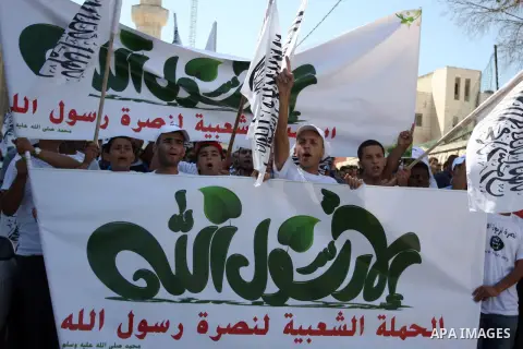 Palestinian protesters shout slogans and wave flags during a protest in the West Bank town of Ramallah against an anti-Islam movie made in the U.S. and French cartoons said to insult the Prophet Muhammad, 21 September 20...