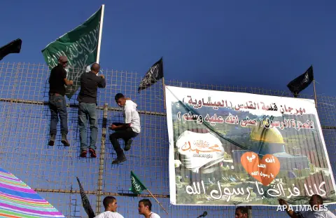 Palestinian Youth they place banners on a fence denouncing an US-produced amateur film mocking Islam's Prophet Mohammed and cartoons published in a French satirical magazine Charlie Hebdo in the Issawiya district of Arab...