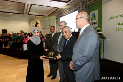 Palestinian Prime Minister Salam Fayyad honors a student during the ceremony of the honoring the superior students in the Palestinian Universities in the year 2012, in the West Bank city of Ramallah, Sept. 23, 2012. Phot...