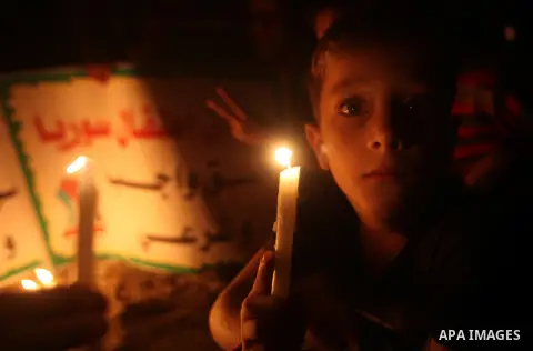 A Palestinian boy holds a candle during a rally to show solidarity with Syrian mothers and children who suffer most in civil war, in Jabalia refugee camp northen Gaza strip, September 24, 2012. The UN Security Council sh...