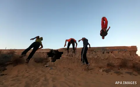 Palestinian youths practice their parkour skills in Khan Younis in southern Gaza Strip on 24 September 2012. Parkour originating in France is the physical practice of traversing elements in both urban and rural settings...