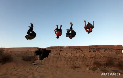 Palestinian youths practice their parkour skills in Khan Younis in southern Gaza Strip on 24 September 2012. Parkour originating in France is the physical practice of traversing elements in both urban and rural settings...