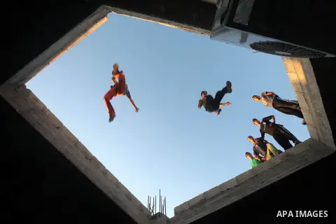 Palestinian youths practice their parkour skills in Khan Younis in southern Gaza Strip on 24 September 2012. Parkour originating in France is the physical practice of traversing elements in both urban and rural settings...