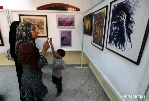 Palestinians look at paintings during an abstract painting show in Gaza city, on 24 September 2012. Photo by Majdi Fathi