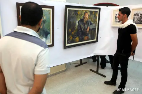 Palestinians look at paintings during an abstract painting show in Gaza city, on 24 September 2012. Photo by Majdi Fathi